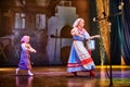 A little girl and an adult woman in Russian national dress rehearsing on stage. Mother and daughter sing and dance together Royalty Free Stock Photo