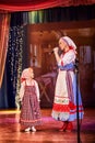 A little girl and an adult woman in Russian national dress rehearsing on stage. Mother and daughter sing and dance together Royalty Free Stock Photo