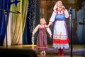 A little girl and an adult woman in Russian national dress rehearsing on stage. Mother and daughter sing and dance together Royalty Free Stock Photo