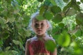 Little girl adventure in common hazel shrubbery hedgerow