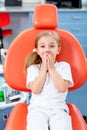 Little girl is afraid to show her teeth to a pediatric dentist. child girl in white clothes at reception at a pediatric dentist Royalty Free Stock Photo