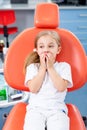 Little girl is afraid to show her teeth to a pediatric dentist. child girl in white clothes at reception at a pediatric dentist Royalty Free Stock Photo