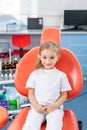 Little girl is afraid to show her teeth to a pediatric dentist. child girl in white clothes at reception at a pediatric dentist Royalty Free Stock Photo