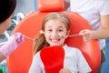 Little girl is afraid to show her teeth to a pediatric dentist. child girl in white clothes at reception at a pediatric dentist Royalty Free Stock Photo