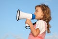 Little girl, against sky, speaks in loudspeaker