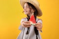 Cute little girl against yellow background, focus on hands with watermelon