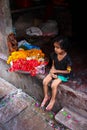 Varanasi, India - August 20, 2009: little girl in an alley preparing flowers in Varanasi, Uttar Pradesh, India