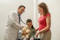 little girl is angry at the doctor office. Mad kid visiting pediatrician. upset child because her mother took her to medic exam Royalty Free Stock Photo