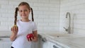 Little girl with apples fruit in kitchen. Copy space.
