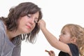 Little girl applying makeup to her mother