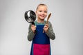 little girl in apron playing with pot and spoon Royalty Free Stock Photo