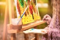 Little girl artist paints a picture on an easel in autumn in the park Royalty Free Stock Photo