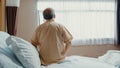 Little girl Asian granddaughter visiting hug sick senior grandfather hospitalized sit on hospital bed in patient room. Royalty Free Stock Photo