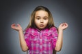 Little girl with astonished expression while standing against grey background Royalty Free Stock Photo