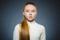 Little girl with astonished expression while standing against grey background