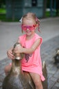 Little girl astride on a duck figure of iron and