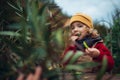 Little girl in autumn clothes eating harvested organic peas in eco garden, sustainable lifestyle. Royalty Free Stock Photo