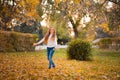 Little girl in autumn orange leaves. happy little child, baby girl laughing and playing in the autumn on the nature walk outdoors. Royalty Free Stock Photo