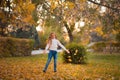 Little girl in autumn orange leaves. happy little child, baby girl laughing and playing in the autumn on the nature walk outdoors. Royalty Free Stock Photo