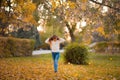 Little girl in autumn orange leaves. happy little child, baby girl laughing and playing in the autumn on the nature walk outdoors. Royalty Free Stock Photo