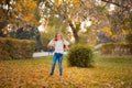 Little girl in autumn orange leaves. happy little child, baby girl laughing and playing in the autumn on the nature walk outdoors. Royalty Free Stock Photo