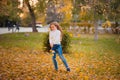 Little girl in autumn orange leaves. happy little child, baby girl laughing and playing in the autumn on the nature walk outdoors. Royalty Free Stock Photo