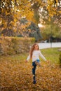 Little girl in autumn orange leaves. happy little child, baby girl laughing and playing in the autumn on the nature walk outdoors. Royalty Free Stock Photo