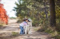 Little girl in autumn Park on a walk with a beautiful dog