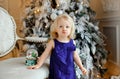 Little girl baby blonde in a blue dress with displeasure pouted
