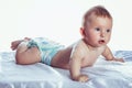 Little girl baby blue eyes lies in diapers Royalty Free Stock Photo