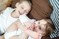 Little girl and baby boy, brother and sister playing in parents bed. Family with children in the morning. Kids play in white Royalty Free Stock Photo