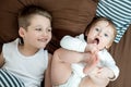 Little girl and baby boy, brother and sister playing in parents bed. Family with children in the morning. Kids play in white Royalty Free Stock Photo