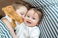 Little girl and baby boy, brother and sister playing in parents bed. Family with children in the morning. Kids play in white Royalty Free Stock Photo