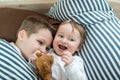 Little girl and baby boy, brother and sister playing in parents bed. Family with children in the morning. Kids play in white Royalty Free Stock Photo