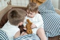 Little girl and baby boy, brother and sister playing in parents bed. Family with children in the morning. Kids play in white Royalty Free Stock Photo