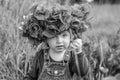 Little girl baby playing happy on the poppy field with a wreath, a bouquet of color A red poppies and white daisies, wearing a den Royalty Free Stock Photo