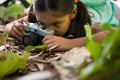 Little girl with backpack lying on floor taking a photo from her camera Royalty Free Stock Photo