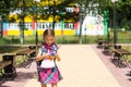 Little girl with a backpack and in a school uniform in the school yard plays pop it toy. Back to school, September 1. The pupil