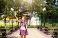 Little girl with a backpack and in a school uniform in the school yard plays pop it toy. Back to school, September 1. The pupil