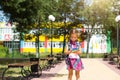 Little girl with a backpack and in a school uniform in the school yard plays pop it toy. Back to school, September 1. The pupil