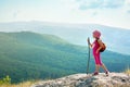 Little girl with backpack standing on cliff edge