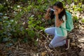 Little girl with backpack taking photo with camera on a sunny day Royalty Free Stock Photo