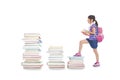 little girl with backpack walking to the top of books