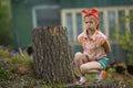 Little girl in a bad mood sitting near the house in the village. Nature. Royalty Free Stock Photo