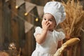 Little girl baker eats loaf of bread and closes her mouth