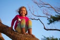 Little Girl Balances on a Tree Branch