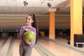 Little girl with ball in bowling. Space for text Royalty Free Stock Photo