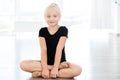 Little girl ballerina sitting with legs crossed in ballet studio Royalty Free Stock Photo