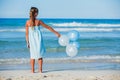 Little girl with ballons on the beach