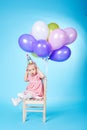 Little girl with balloons on blue background Royalty Free Stock Photo